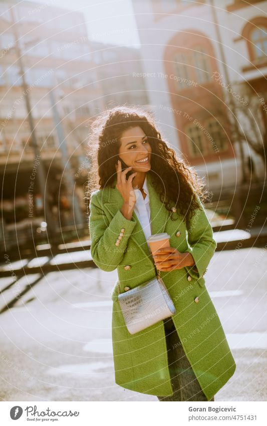 Young woman using smartphone on the street and holding takeaway coffee beautiful people beautiful woman casual cellphone cheerful city city life city street