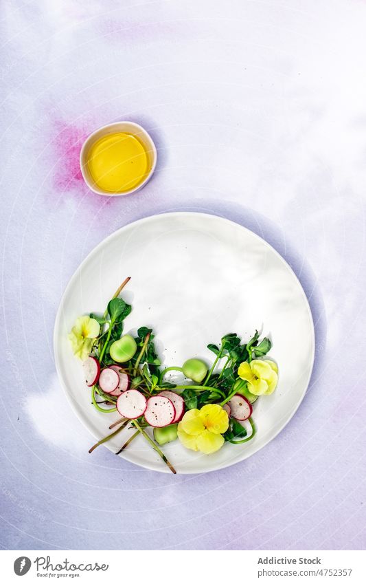 Herbs and radish salad with flowers vegetarian herb sauce oil garnish haute cuisine sophisticated vegetable bowl plate serve veggie vegan delicious healthy food