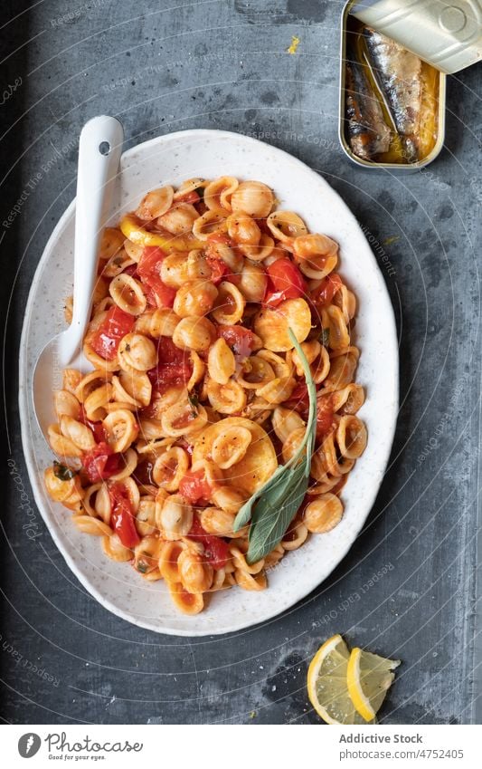 Plate of delicious Italian pasta tomato sauce sardine lemon table lunch conchiglie dish italian cuisine can plate food spoon serve portion dinner culinary