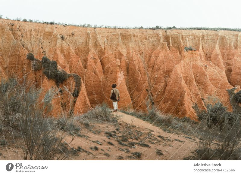 Anonymous male traveler admiring rock in nature man admire mountain countryside trip highland explore journey adventure ridge range arid dry canyon hill