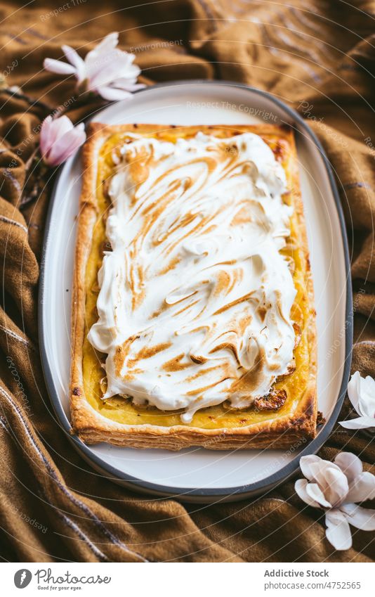 Plate with meringue cake on cloth dessert pastry plate flower tasty food sweet delicious baked fabric yummy treat oval confectionery appetizing portion