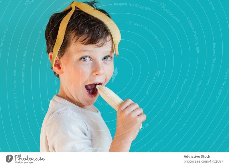 Funny boy with banana peel on head kid having fun childhood carefree playful smile portrait fruit eat cheerful ripe happy positive vitamin fresh sweet glad