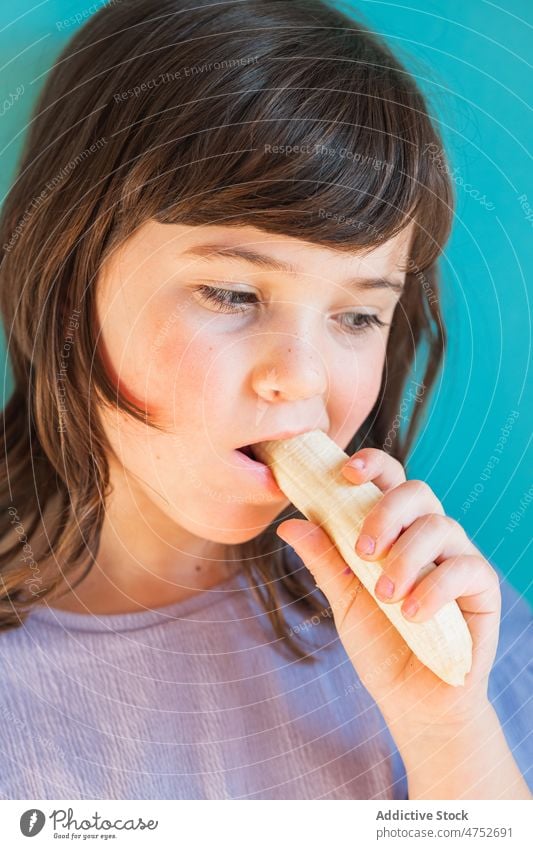 Girl eating ripe banana girl kid childhood fruit organic healthy food natural fresh sweet studio appearance vitamin cute mood hungry tasty pleasant colorful