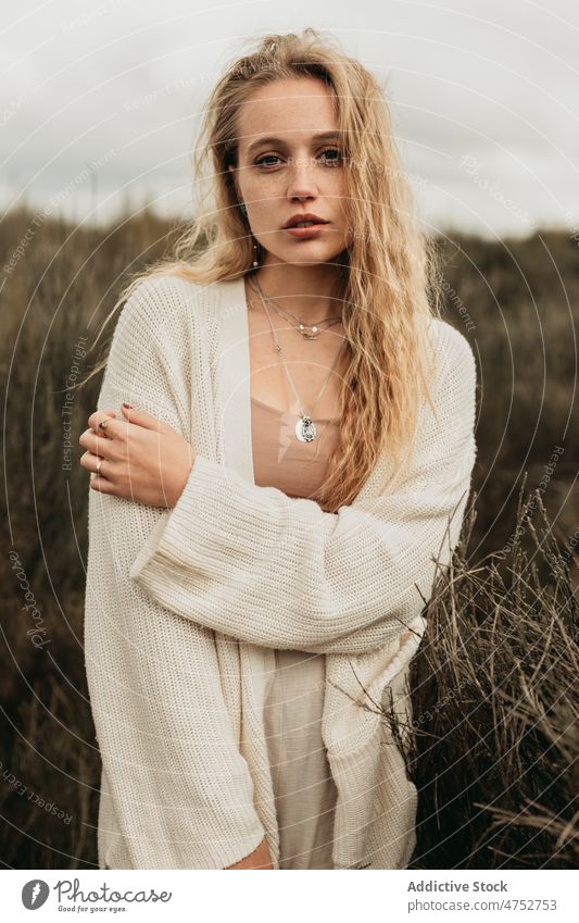 Woman standing on grassy field in countryside woman portrait nature appearance feminine style attractive young rural female blonde environment gloomy rustic