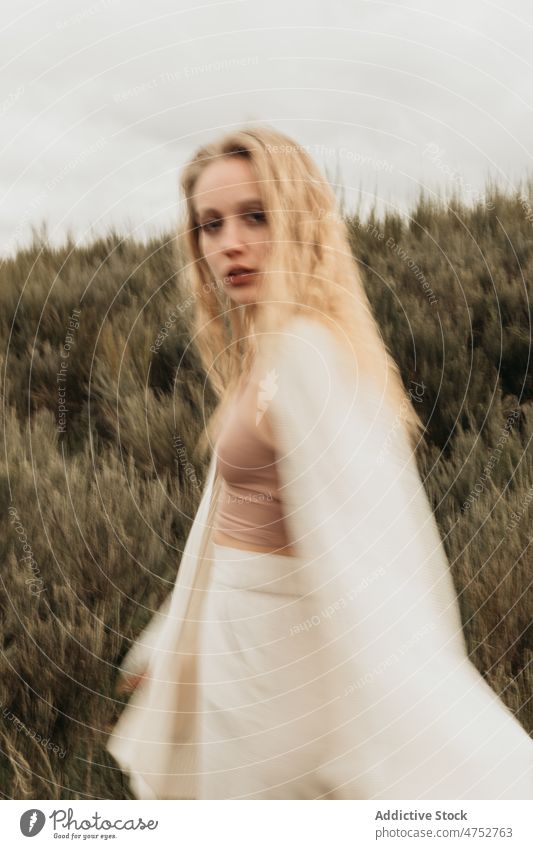 Woman standing on grassy field in countryside woman portrait nature appearance feminine style attractive young rural female blonde environment gloomy rustic