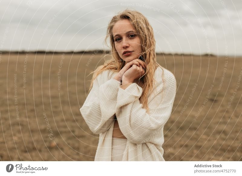 Woman standing on grassy field in countryside woman portrait nature freckles appearance feminine style attractive young rural female blonde environment gloomy