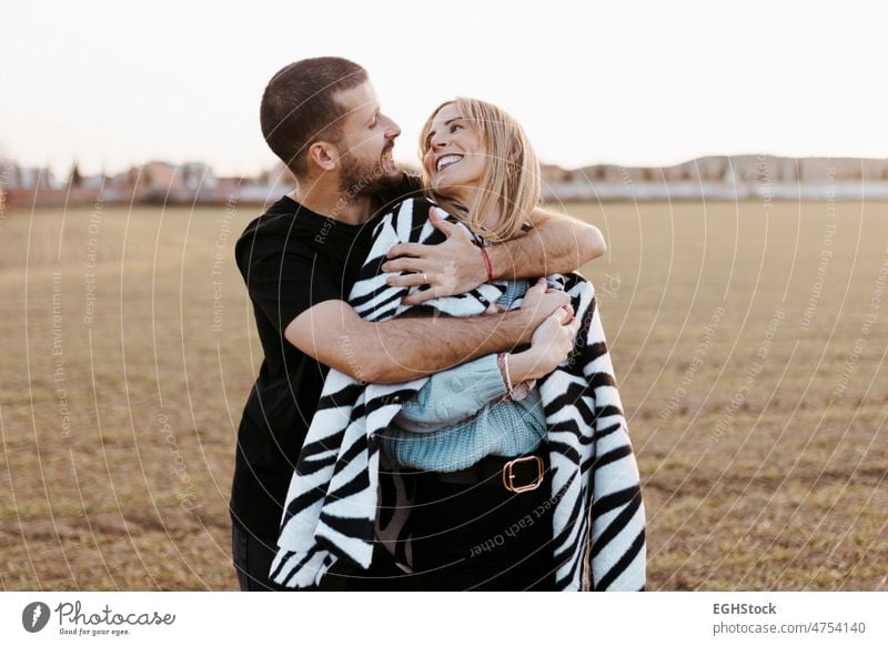 Young couple dancing outdoor through meadow in countryside, kissing. Boyfriend and girlfriend in love weekend people man woman adult nature outdoors