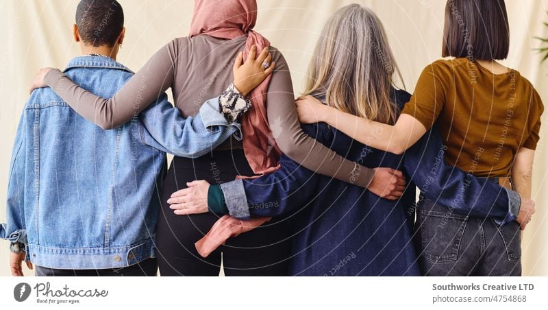 International Women's Day rear view portrait of four women standing with arms around each other in solidarity international womans day back friend bonding