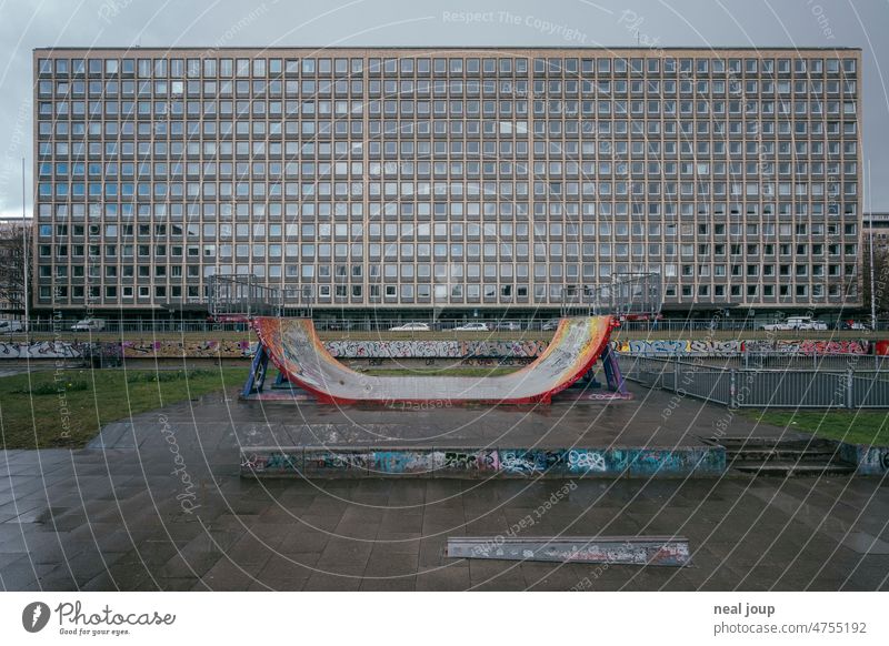 Half Pipe in front of an anonymous urban skyscraper facade Town High-rise Facade Gloomy Monochrome Window Halfpipe Skateboarding Deserted shabby Building