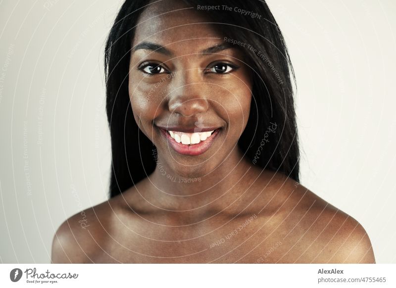 Young beautiful long haired woman standing in front of white wall looking at camera Woman Young woman pretty Beauty & Beauty Graceful Joy Friendliness kind