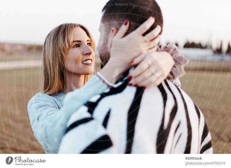 Female looking her boyfriend. Close up couple nose kissing in the countryside embraced. Boyfriend and girlfriend in love fall close up hugging two people