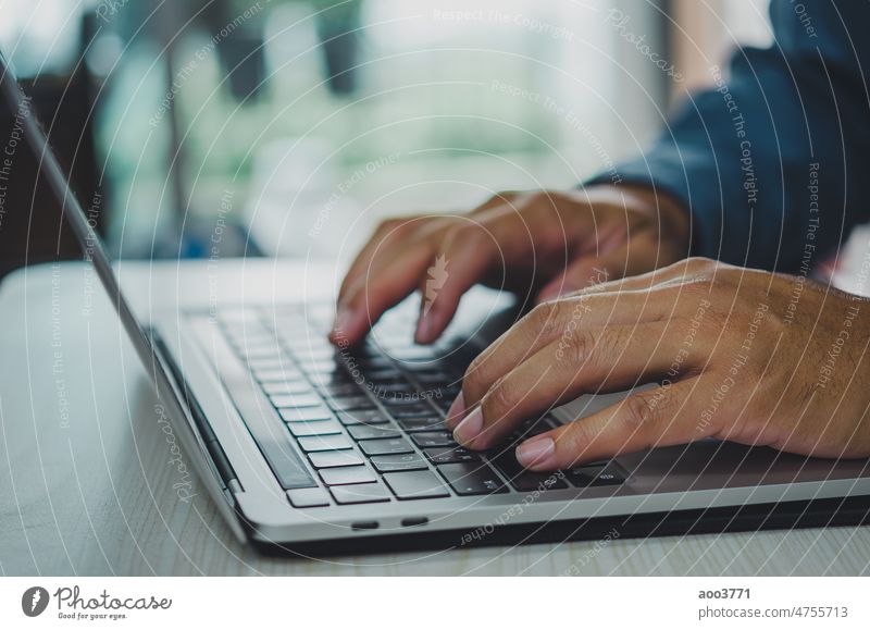 man using computer laptop searching internet, sending sms, using text messenger or online banking. business typing technology businessman keyboard male work