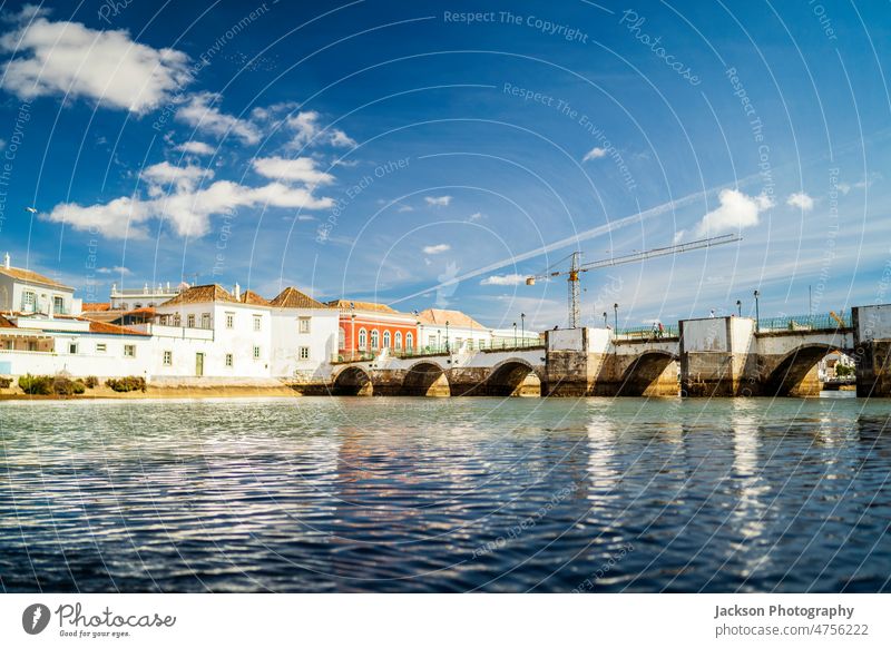 Beautiful cityscape of historic Tavira by Gilao river, Algarve, Portugal tavira algarve bridge architecture boat home outdoors european landmark blue sky