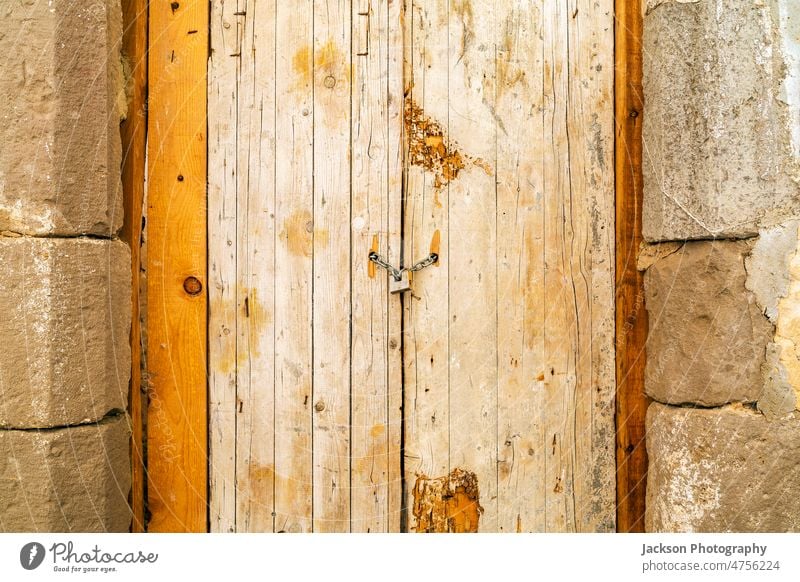 Rusty padlock locking old wooden door with a chain portugal tavira facade locker key abandoned aged entrance weathered rusty rustic grunge hardwood building