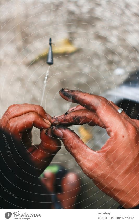 Close up dirty hand put bait worm on the hook. fisherman prepared for fishing animal earthworm catch isolated lure nature fishhook hobby sport fishing hook