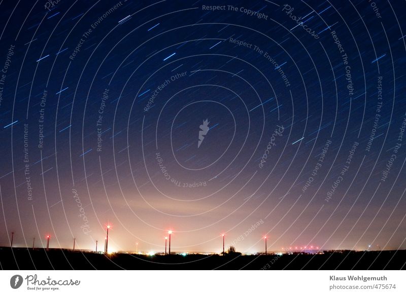 Friedland, a small town in Mecklenburg-Vorpommern, exudes its light under the starry sky, framed by wind farms. Far-off places Winter Energy industry