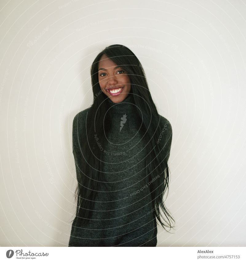 Young beautiful long haired woman standing in front of white wall smiling at camera Woman Young woman pretty Beauty & Beauty Graceful Joy Friendliness kind