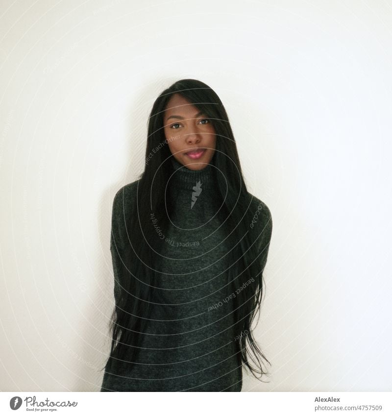 Young beautiful long haired woman standing in front of white wall looking at camera Woman Young woman pretty Beauty & Beauty Graceful Joy Friendliness kind