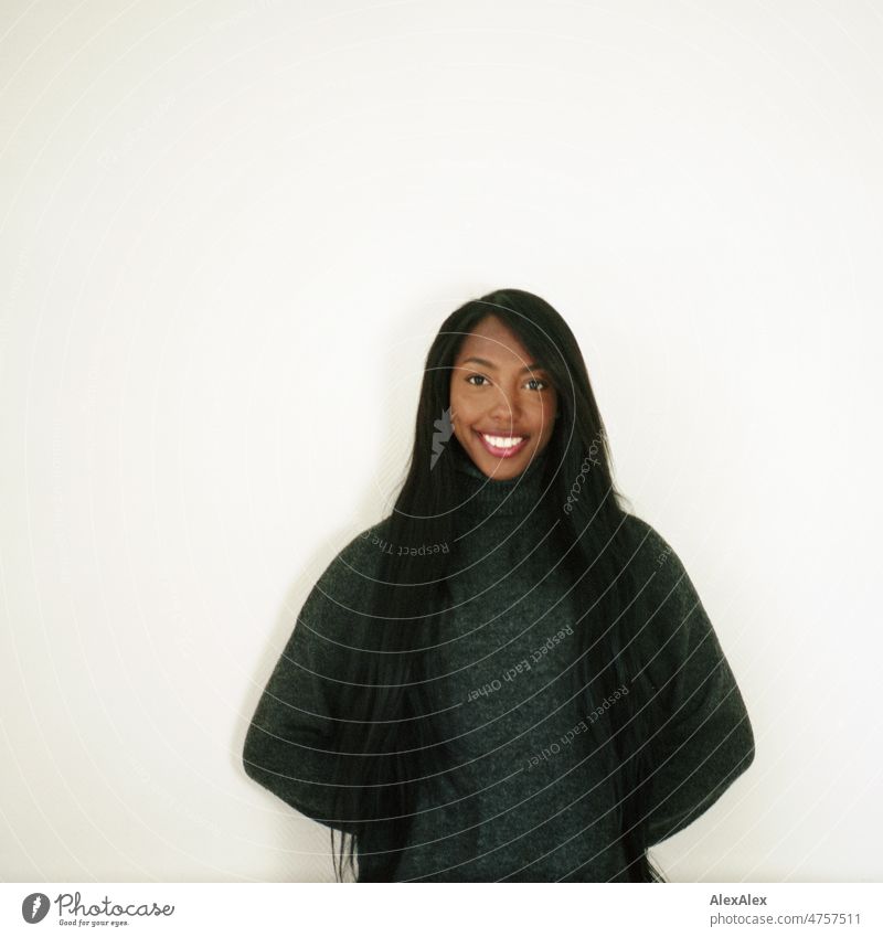 Young beautiful long haired woman standing in front of white wall smiling at camera Woman Young woman pretty Beauty & Beauty Graceful Joy Friendliness kind