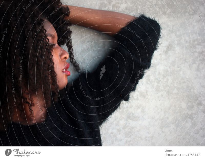 Woman with bent arm portrait Profile Sweater Curl Dark-haired Wall (barrier) Stand Wall (building) Earnest Forward Feminine Long-haired