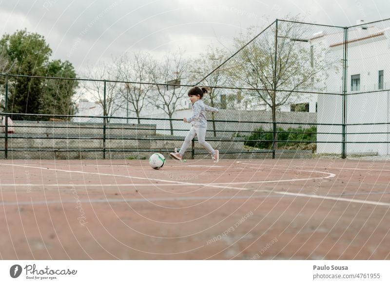 Cute girl playing football Girl 3 - 8 years Child childhood Football pitch Playing Life Soccer Day Joy Human being Colour photo Exterior shot Sports