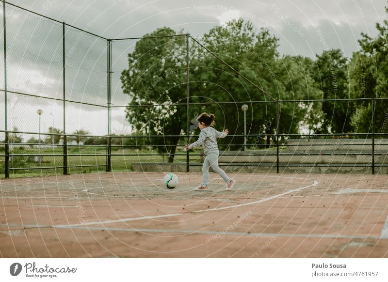 Cute girl playing football Girl 3 - 8 years Child childhood Football pitch Playing Life Soccer Day Joy Human being Colour photo Exterior shot Sports