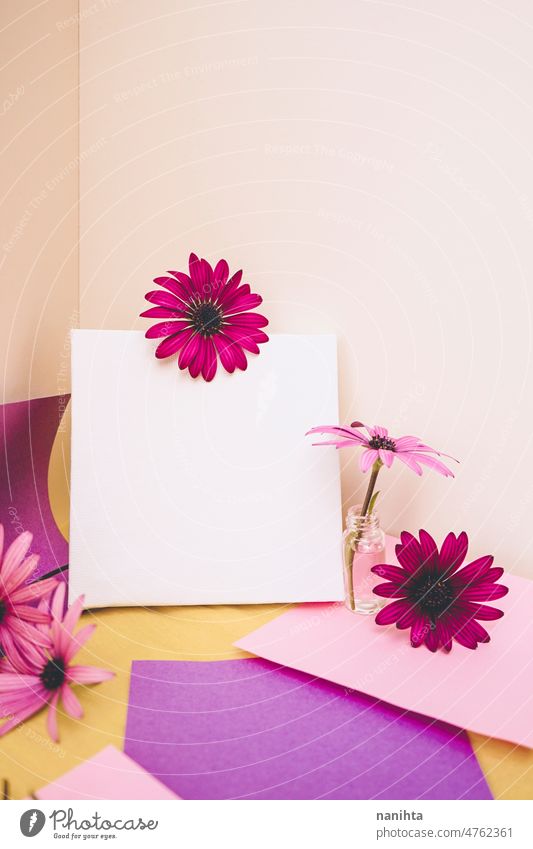 Mockup image with a white canvas surrounded by color papers and flowers mockup spring design colorful vibrant post-it sticky notes yellow purple pink tones