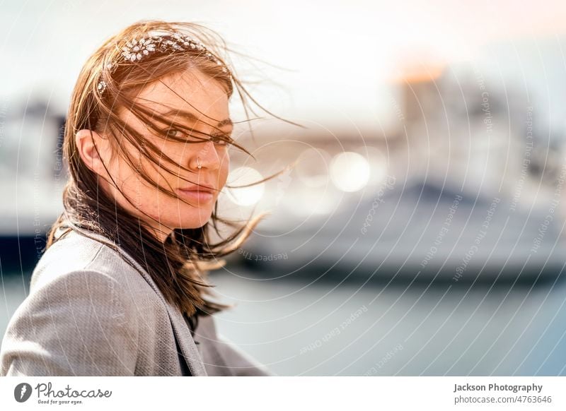 A portrait of an attractive young woman with hair on her face wind windy hidden copy space serious hide one confident outdoor independent tourist student