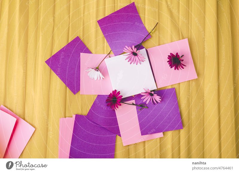 Mockup image with a white canvas surrounded by color papers and flowers mockup spring design colorful vibrant post-it sticky notes yellow purple pink tones