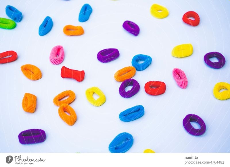 Colorful background of multi colored ponytail holders against baby blue background colorful flat lay childhood weird mess dissorder joy happiness clean light