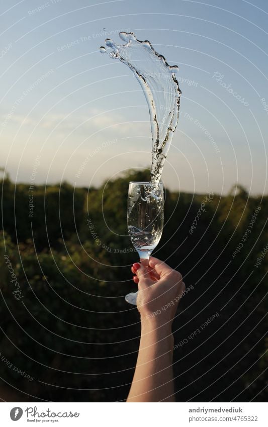 female hand holding a glass of fresh water on a nature and sky background drink woman girl health healthy lifestyle young beverage diet natural person clean