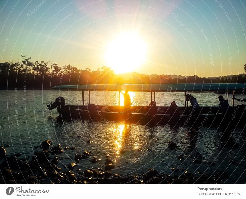 Silhouette of people in a boat sailing on the river at sunset. silhouette yellow man raft tree water summer nature mountain travel beautiful outdoor reflection