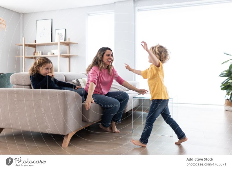 Mother hugging son near daughter mother children sibling pastime spend time living room love childhood cuddle caress embrace motherhood bonding together