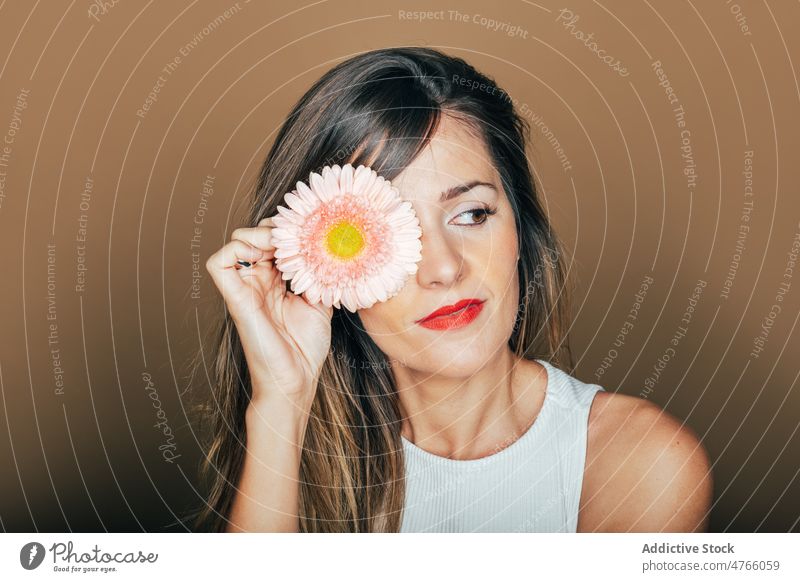 Woman covering eye with gerbera flower in studio woman model delicate portrait gentle pink style tender female red lips cover eyes natural feminine romantic