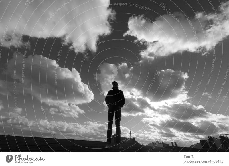 a man under the sky of Berlin in the wind Man Television tower bnw b/w roof Television Tower Berlin Town Day Exterior shot Downtown Capital city