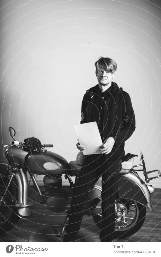 man with white sheet stands by old motorcycle in studio Studio shot Motorcycle MZ b/w Trzoska Black & white photo B/W Day B&W Calm Berlin Man Blonde