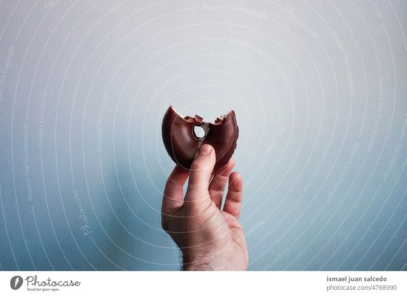 hand with a chocolate donut fingers doughnut food pastry breakfast baked bakery snack brown sweet delicious dessert tasty fresh meal meat gourmet cake pastries