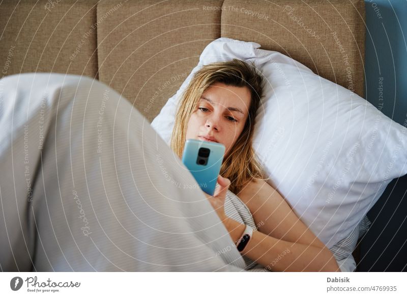 Woman using smartphone in the bed, Social media, Lazy weekend woman morning online relax hold lazy social screen cell time sleep chat tired girl mobile