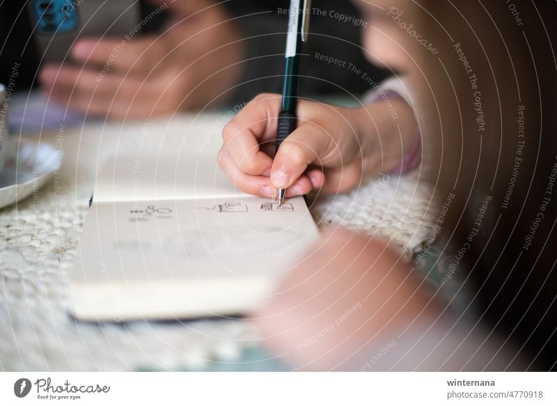 Children is writing, dad is watching his phone, table drawning child pen hands write home education people studying kid young joy homework learning sitting