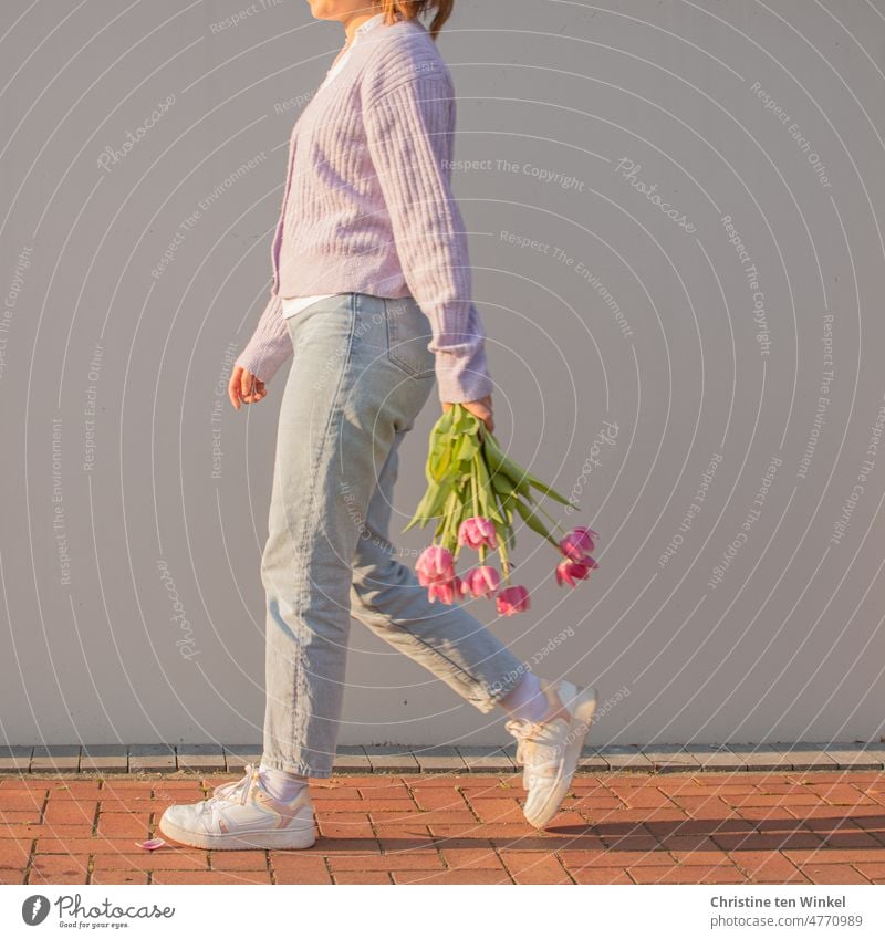 Swinging into Monday... Young woman with bouquet of tulips in hand walks along in front of bright wall Walking Spirited Bouquet Spring portrait blossom flowers