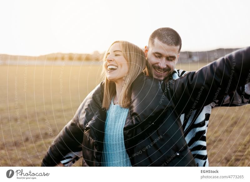 Young couple dancing outdoor through meadow in countryside, kissing. Boyfriend and girlfriend in love weekend people man woman adult nature outdoors