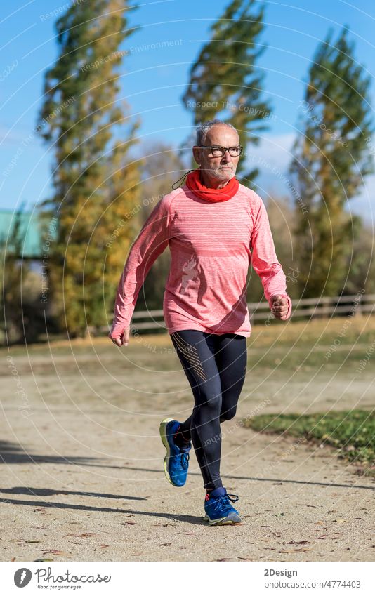 A senior man dressed in black and green is running in the park Jogging 60s Male 70s Adult Copy Space Enjoyment Front View Lifestyle Mature Men Nature Outdoors