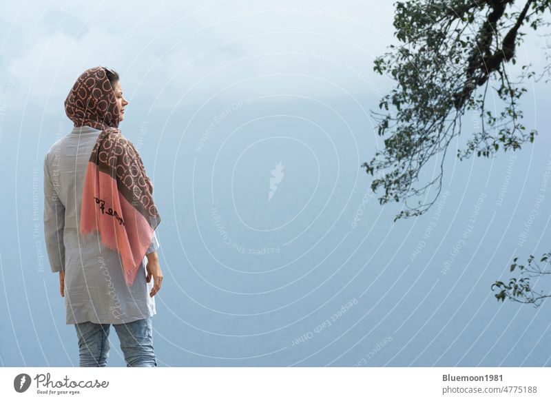 Rear viewpoint of a young Muslim woman enjoying in the misty landscape people backside freedom lifestyle hiking female healthy nature outdoor alone relax rest