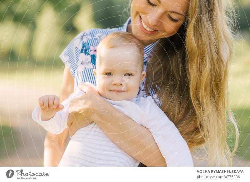 Happy mother playing with her baby in her arms smiling child son boy love people caucasian family female happy holding little woman young childhood cute outdoor