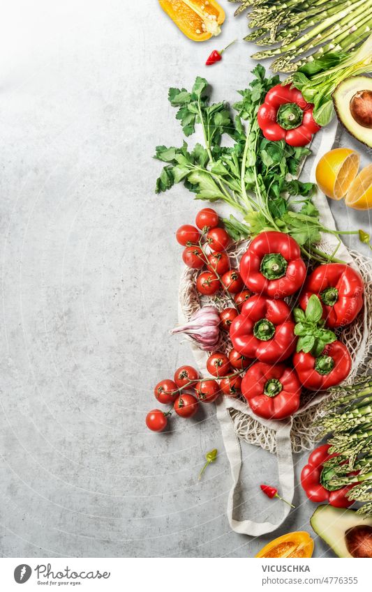 Various vegetables on grey background with reusable shopping bag. Plastic free groceries. food various plastic free bell pepper herbs asparagus tomatoes garlic