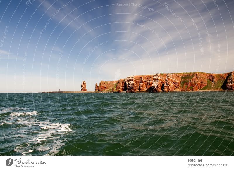 My favorite island Helgoland seen from the sea side. You can see the beautiful reddish sandstone rocks and the landmark, the long Anna. Tall Anna Rock Island