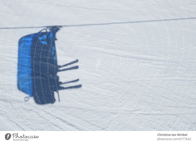 The shadow rides with... Chairlift armchair and 2 pairs of skis as shadow on the snow chair lift Shadow Skis Winter sports Skiing Winter vacation Snow Ski run