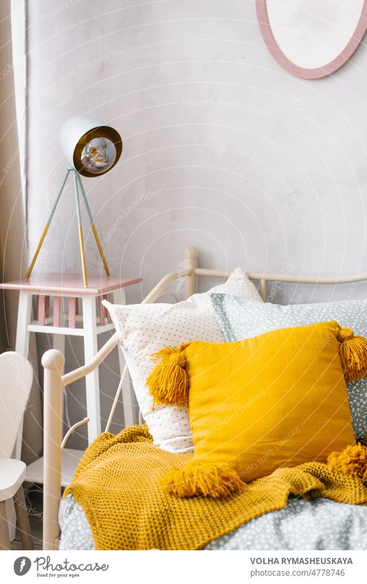 Close-up of the orange pillow, the headboard in the bedroom and the night light near the bed in the bedroom interior apartment contemporary cushion furniture