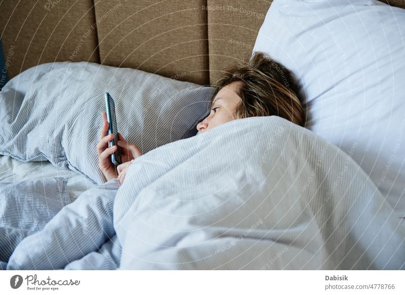 Woman using smartphone in the bed, Social media, Lazy weekend woman morning online relax hold lazy social screen cell time sleep chat tired girl mobile