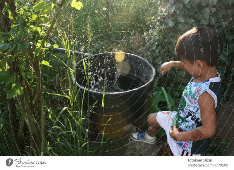 little boy playing at water barrel in garden Child Toddler Water Playing vat Infancy Boy (child) Joy Happiness Exterior shot fun Summer Joie de vivre (Vitality)